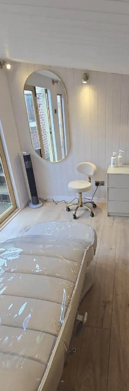 The Seasons Glow treatment room with oval mirror and treatment bed