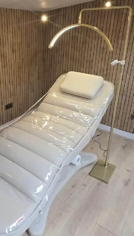 Treatment bed under a gold arch lamp